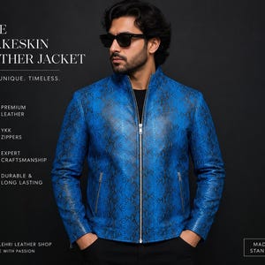 Op de afbeelding: Een felblauwe leren jas met een slangenleer textuurpatroon, een centrale zilveren rits en twee zijzakken met rits. De tekst op de afbeelding luidt: BLUE SNAKESKIN LEATHER JACKET, BOLD. UNIQUE. TIMELESS., PREMIUM LEATHER, YKK ZIPPERS, EXPERT CRAFTSMANSHIP, DURABLE & LONG LASTING, BILAL SULEHRI LEATHER SHOP, HANDMADE WITH PASSION, MADE TO STAND OUT.