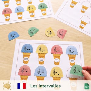 Op de afbeelding: Educatieve muziek flashcards met ijsjesontwerpen, muzieknoten en intervallen. De flashcards zijn in verschillende kleuren, met de tekst "Les intervalles" onderaan.