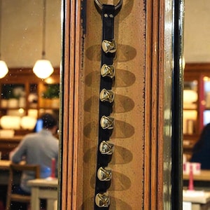 May include: A white ceramic mug with a black handle and the text "But First, Coffee" in a bold, black font. The mug is set against a neutral background, highlighting its simple design.