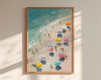 May include: A framed painting of a beach scene in a wooden frame. The artwork shows a sandy beach with colourful parasols, people, and the sea. The parasols are various colours, including orange, yellow, pink, and blue. The painting has a textured, impressionistic style.