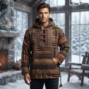 Può includere: Un pullover con cappuccio a maniche lunghe caratterizzato da un motivo a righe multicolore nei toni del vino, verde e marrone. Il capo include una tasca a marsupio frontale, un cappuccio e un'abbottonatura parziale con tre bottoni rotondi. Testo Wine Tone.
