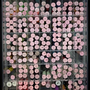 May include: A clear acrylic organizer case filled with numerous spools of metallic embroidery thread. Each spool features a round pink label on top displaying specific color codes and the length of 10M. The spools are arranged in grid compartments.
