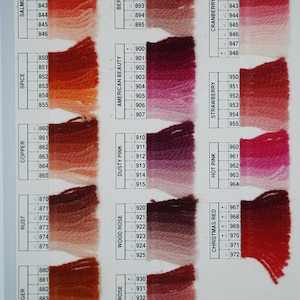 May include: Color chart featuring various shades of yarn, including salmon, spice, copper, rust, ginger, berry, American beauty, cranberry, strawberry, hot pink, wood rose, dusty pink, rusty rose, and Christmas red. Each color is labeled with a number.