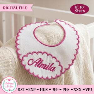 Puede incluir: Babero blanco para bebé con borde festoneado y borde bordado rosa. El nombre "Almila" está bordado en rosa. El babero es un archivo digital disponible en tamaños de 20,3 cm y 25,4 cm. El texto "ARCHIVO DIGITAL" está en la parte superior.