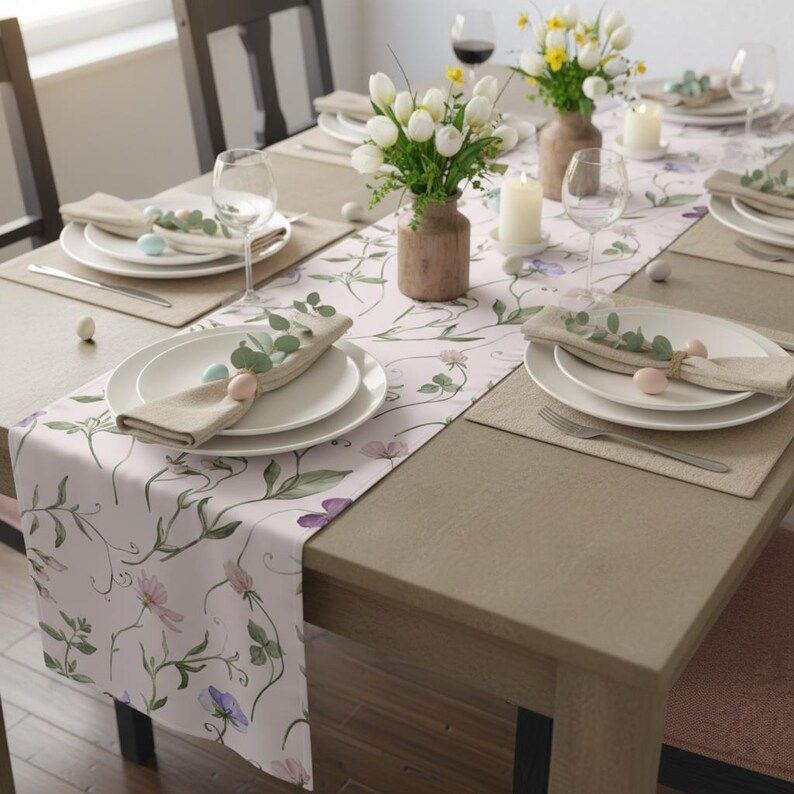 Peut inclure: Une table de salle &agrave; manger dress&eacute;e pour une c&eacute;l&eacute;bration printani&egrave;re. La table est orn&eacute;e d'un chemin de table floral, d'assiettes blanches, de serviettes beiges et d'&oelig;ufs de P&acirc;ques aux couleurs pastel. Des vases de tulipes blanches et des bougies compl&egrave;tent l'ambiance festive.