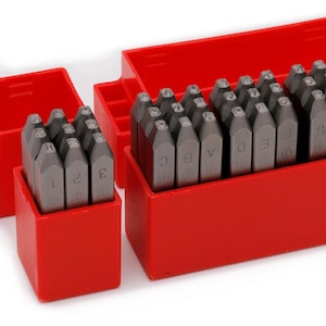 Può includere: Un set di timbri in metallo con lettere e numeri in una custodia di plastica rossa. I timbri sono disposti in tre scomparti separati. Le lettere dalla A alla I sono visibili. Sono visibili anche i numeri 1, 2 e 3.