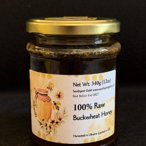 May include: A jar of 100% raw buckwheat honey with a gold lid. The label features a watercolor illustration of a honey pot, bees, and flowers. The jar contains 340g of honey.