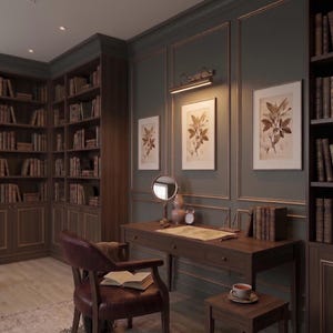 Elegant brass art display light providing warm illumination for paintings and mirrors.