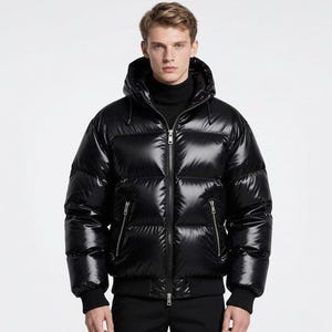 May include: A shiny black puffer jacket with a hood and a zip-up front. The jacket has a ribbed hem and cuffs, and two zippered pockets. The model is wearing a black turtleneck underneath.