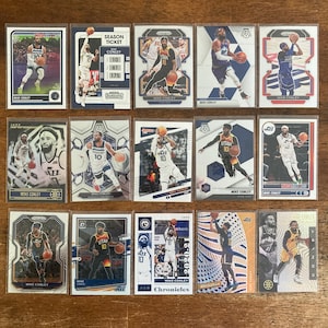 May include: A collection of 12 trading cards featuring basketball player Mike Conley. The cards are from different sets and feature different photos of Conley in his Utah Jazz and Memphis Grizzlies uniforms. The cards are in mint condition and are perfect for any basketball fan.