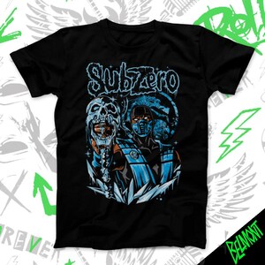 Op de afbeelding: Zwart t-shirt met een afbeelding van Sub-Zero uit Mortal Kombat. Het ontwerp bevat een schedel, het gezicht van het personage en het woord "Subzero" in blauw. De illustratie heeft een stripboekstijl.
