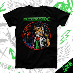 May include: Black t-shirt featuring a Star Fox graphic. The design includes the text "STARFOX" in green, a cartoon fox character, and a space scene with planets and ships. The fox is wearing a white jacket with a green vest and a red scarf.