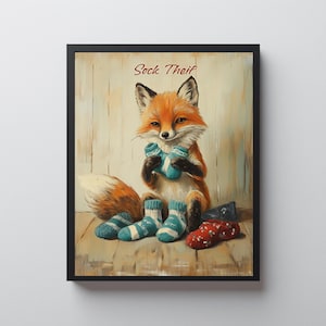 May include: Framed art print featuring a whimsical fox with orange fur and a fluffy tail, holding blue and white socks. The artwork includes the text "Sock Theif" in a decorative font, set against a rustic wooden background.