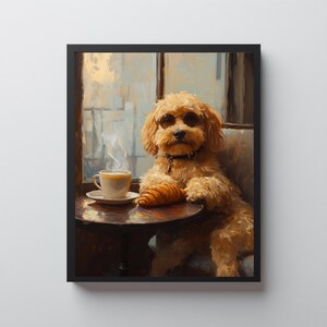 Pode incluir: Uma impressão emoldurada mostra um cão usando óculos de sol, sentado em uma mesa com um croissant e uma xícara de café. O cão é marrom claro com pelo encaracolado. A mesa é marrom escuro, e o fundo mostra uma janela.