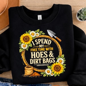 May include: Black sweatshirt with a gardening-themed graphic. The design features sunflowers, daisies, and the text "I Spend My Free Time With Hoes & Dirt Bags." A trowel and a bag of dirt are also included.
