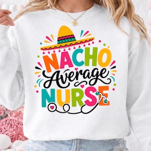 May include: White sweatshirt with a colorful graphic that reads "Nacho Average Nurse." The design includes a sombrero, hearts, and a stethoscope. The text is in various bright colors, making it a fun and eye-catching design.