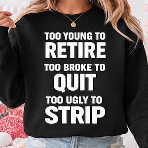 May include: Black sweatshirt with the text "TOO YOUNG TO RETIRE TOO BROKE TO QUIT TOO UGLY TO STRIP" in white block letters. The sweatshirt is a casual garment.