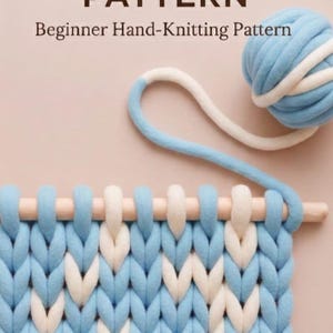 以下が含まれることがあります： 「YARN BLANET PATTERN」と「Beginner Hand-Knitting Pattern」の文字が入った手編みのブランケットパターンのクローズアップ。ブランケットは青と白で、木製の編み針が付いています。青と白の糸玉が背景にあります。