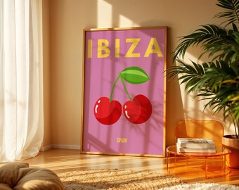 Puede incluir: Un póster enmarcado con la palabra "IBIZA" en letras amarillas sobre un fondo rosa. Debajo, un gráfico de dos cerezas rojas con una hoja verde. La palabra "SPAIN" está impresa debajo de las cerezas.