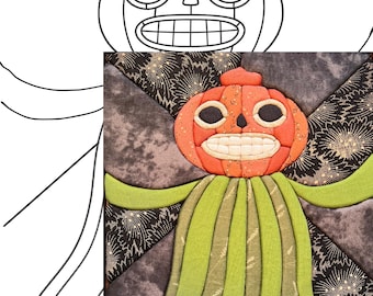 Puede incluir: Un bloque de edredón de tela que presenta una cabeza de calabaza naranja central con una amplia sonrisa dentada y ojos circulares oscuros. La calabaza está sobre un fondo de tela gris oscuro con patrones de estrellas doradas y tiras de tela verde.