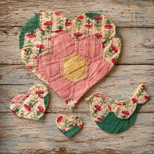 May include: A selection of handmade fabric items in heart and bird shapes. The large heart-shaped piece features a pink flower design with a yellow centre. Smaller hearts and a bird-shaped item are also present, all with a floral pattern and green accents.
