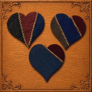 May include: Three heart-shaped fabric patches featuring a patchwork design of black, dark blue, and deep red textile segments. Each heart is joined by visible yellow cross-stitch embroidery detailing along the seams of the fabric pieces.