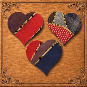 May include: Three heart-shaped fabric ornaments featuring patchwork designs in red, brown, blue, and grey. Each heart is constructed from multiple fabric pieces joined by visible yellow cross-stitching, set against a wood-toned square frame.