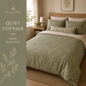 May include: A sage green cotton duvet cover featuring a delicate white botanical leaf pattern. The bedding set includes two matching pillowcases and a long, rectangular bolster pillow with a subtle beige and white vertical stripe design.