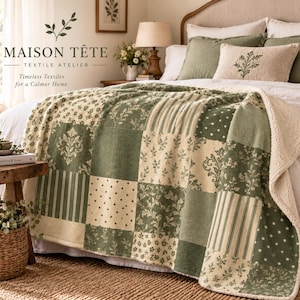 May include: A patchwork throw blanket featuring alternating squares of sage green and cream fabric with floral, striped, and polka dot patterns. The blanket has a white sherpa fleece lining and is draped over a bed with matching green pillows.