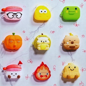 Puede incluir: Nueve fundas para AirPods de estilo caricatura y coloridas. Los diseños incluyen un rollo de sushi, una mancha amarilla, una rana verde, una calabaza naranja, un erizo, un oso, una llama y un cacahuete. Cada funda tiene una cara única.
