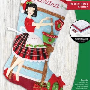 May include: A Bucilla felt stocking kit titled Rockin' Retro Kitchen, measuring 18 inches. The light blue stocking features a retro-style figure in a red top and plaid skirt, a green mixing bowl, and two gift boxes with red bows at the bottom.