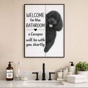 Könnte beinhalten: Schwarz gerahmtes Badezimmer-Wandbild mit dem Text "WELCOME to the BATHROOM a Cavapoo will be with you shortly" und einer Illustration eines schwarzen Cavapoo-Hundes. Die Kunst wird über einem Badezimmerwaschbecken gezeigt.
