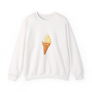 Könnte beinhalten: Weißes Sweatshirt mit Rundhalsausschnitt und einer Aquarellillustration einer Softeiswaffel. Das Eis hat ein Wirbeldesign in Gelb- und Weißtönen, und die Waffel ist hellbraun.