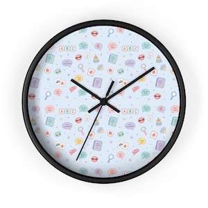 May include: A round wall clock with a black frame. The clock face is light blue and covered in colorful illustrations of speech bubbles, ABC blocks, and other educational icons. The clock hands are black.