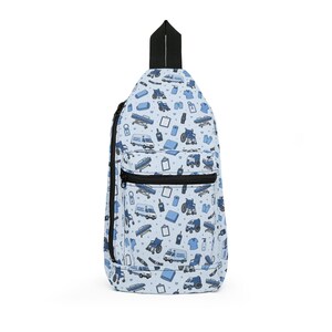 May include: A light blue sling backpack with a black zipper and strap. The bag is covered in a pattern of medical-themed illustrations in shades of blue and white, including ambulances, stretchers, and wheelchairs.