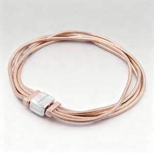 May include: Rose gold bracelet featuring multiple strands of woven metal. The bracelet has a silver clasp with the brand name "Pandora" engraved on it. The bracelet is designed to be worn around the wrist and is displayed on a white background.