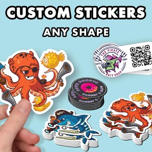 May include: Custom stickers in various shapes, including an octopus, a fish, and a donut. The stickers are printed on white paper and have a glossy finish. The text "CUSTOM STICKERS ANY SHAPE" is printed at the top of the image.