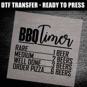 May include: A DTF transfer with the text "DTF TRANSFER - READY TO PRESS". The design features "BBQ Timer" in a script font, with cooking levels and beer quantities: Rare (1 beer), Medium (2 beers), Well Done (3 beers), and Order Pizza (6 beers).