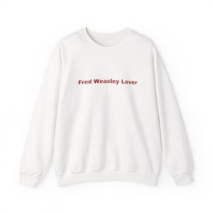 Puede incluir: Sudadera blanca de cuello redondo con el texto "Fred Weasley Lover" en color granate. La parte superior de manga larga está hecha de un material suave y es adecuada para uso informal. Una sudadera cómoda y elegante.