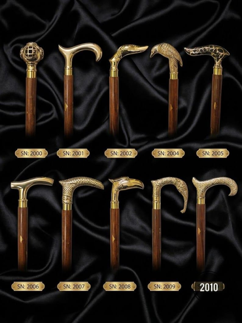 May include: A collection of ten walking sticks with dark brown wooden shafts and ornate brass handles. The handles feature various designs including a diver helmet, animal heads, and textured patterns. Each stick is labelled with a serial number.