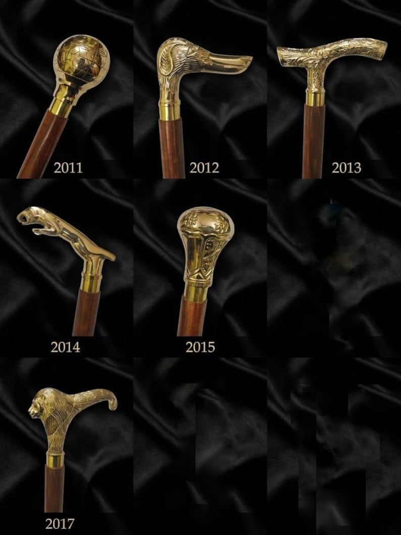 May include: A collection of seven walking sticks with dark wooden shafts and polished brass handles. The handles feature distinct designs including a globe, a duck head, an ornate curved grip, a leaping panther, a textured knob, and a lion head.