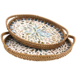 Könnte beinhalten: Zwei ovale Serviertabletts mit gewebten Rattanrändern und Griffen. Die Tablettinnenräume weisen ein Mosaikdesign aus schillernden Muschelteilen und blauen Akzenten auf. Die Tabletts sind gestapelt und zeigen die aufwendige Handwerkskunst.