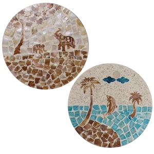 May include: Two round mosaic coasters. One depicts elephants under a tree, the other shows dolphins near palm trees. The mosaics use brown, white, and blue tiles, creating a decorative, artistic design.