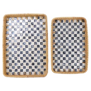 Può includere: Due vassoi rettangolari con un motivo a scacchi di quadrati bianchi e blu navy. I vassoi hanno bordi intrecciati marrone chiaro.