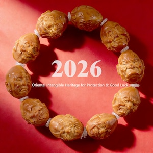 May include: A bracelet featuring carved, light brown beads depicting detailed faces, strung together with white connectors. The number "2026" is displayed in white, along with the text "Oriental Intangible Heritage for Protection & Good Luck" on a red background.