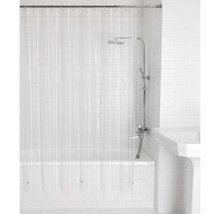 May include: A clear, transparent shower curtain hangs in front of a white bathtub. The shower curtain is suspended from a metal rod. A chrome shower head and faucet are visible, along with white tiled walls and a white sink.