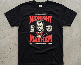 May include: A black short-sleeve t-shirt featuring a graphic print with the text Midnight Mayhem, Thirteen29 Presents, and Classic Horror & Sci-Fi Costume Party. The design includes a central illustration of a cat-like figure in a tuxedo.