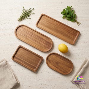 May include: A collection of four wooden serving trays in rectangular and oval shapes with raised edges. The set includes one long rectangular tray, one long oval tray, one small rectangular tray, and one small oval tray, accompanied by a lemon and herbs.