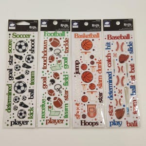 May include: Four sheets of self-adhesive sports-themed stickers. The sheets feature soccer, football, basketball, and baseball designs. Each sheet includes sports equipment and related words like "goal," "team," and "shoot."