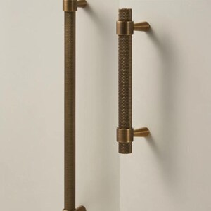 May include: A set of three ceramic mugs with a speckled, matte finish. The mugs are in shades of cream, light gray, and dark gray. Each mug has a simple, minimalist design and a rounded handle.